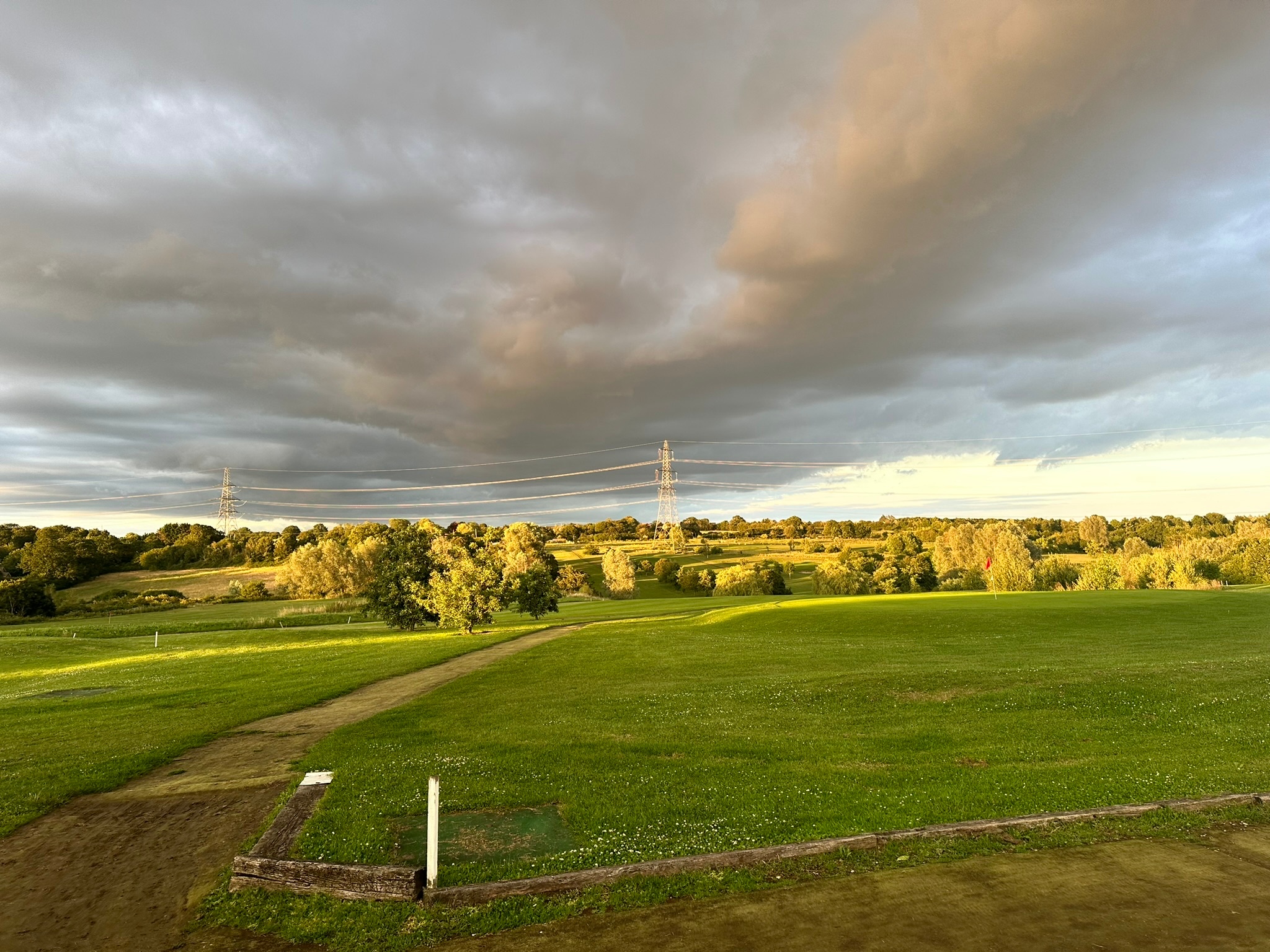 Wide fairway view under dramatic cloud cover at The Notleys